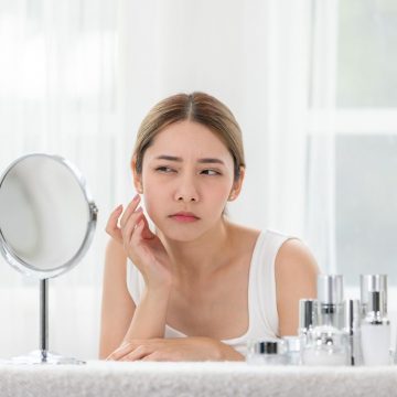 鏡を見て悩む女性