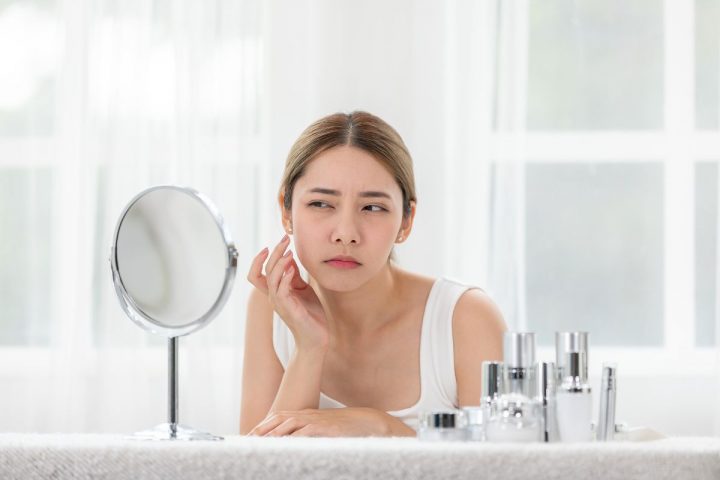 鏡を見て悩む女性